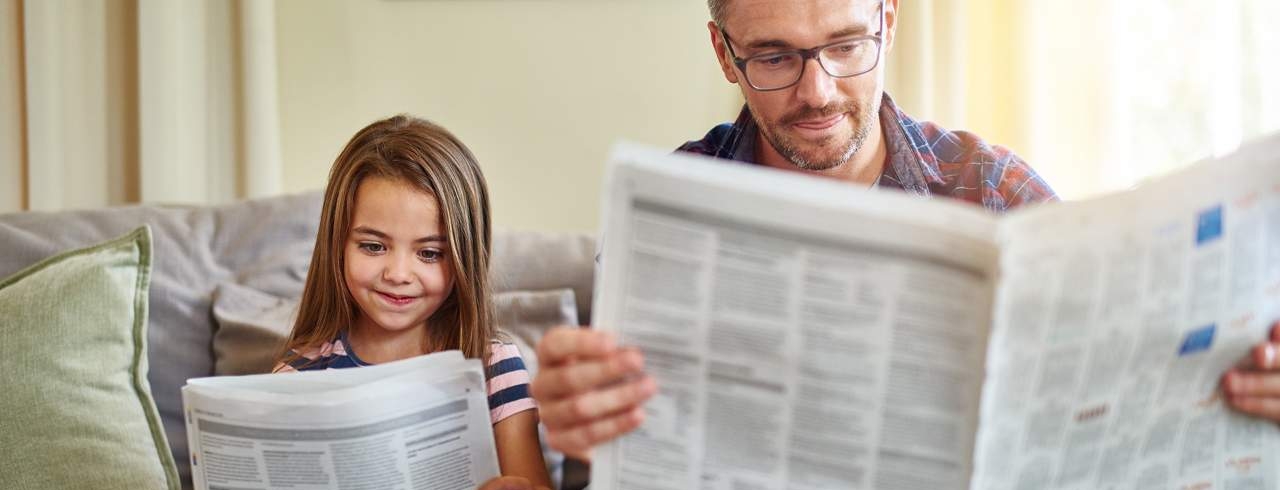 Vater und Tochter lesen Zeitung