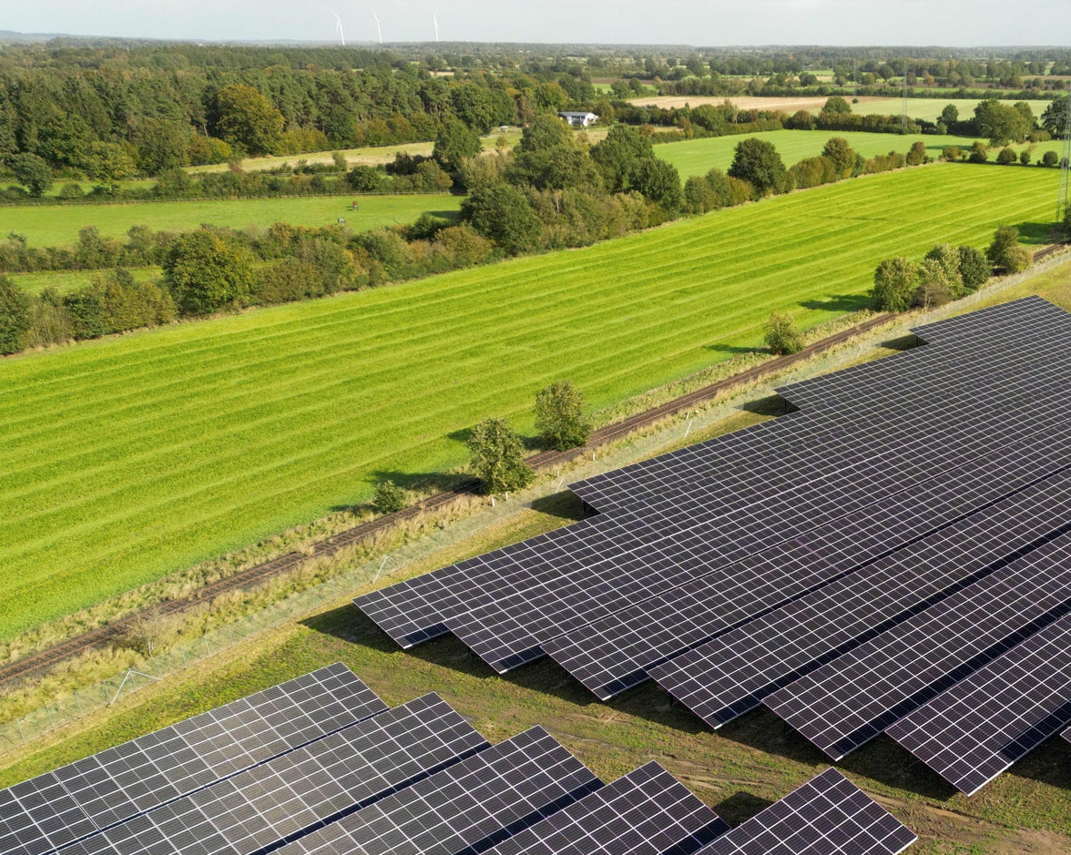 PV-Module einer Solarfreiflächenanlage umgeben von grünen Wiesen 