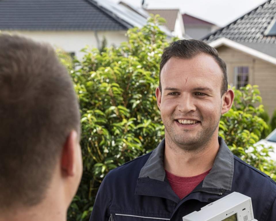 Mitarbeiter mit neuem Zähler beim Kunden